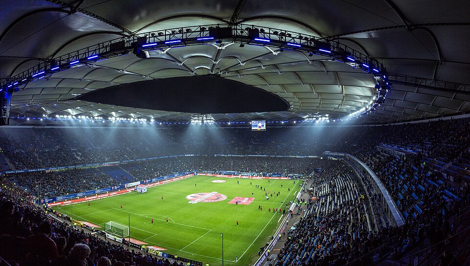 Estadio iluminado durante un partido de fútbol nocturno